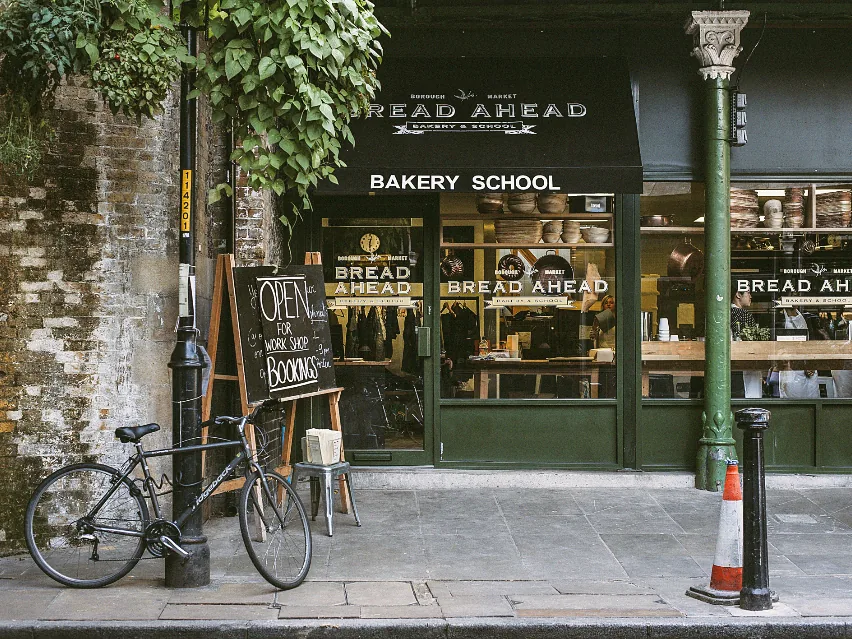 A small bakery shopfront with an open sign and a bike parked outside