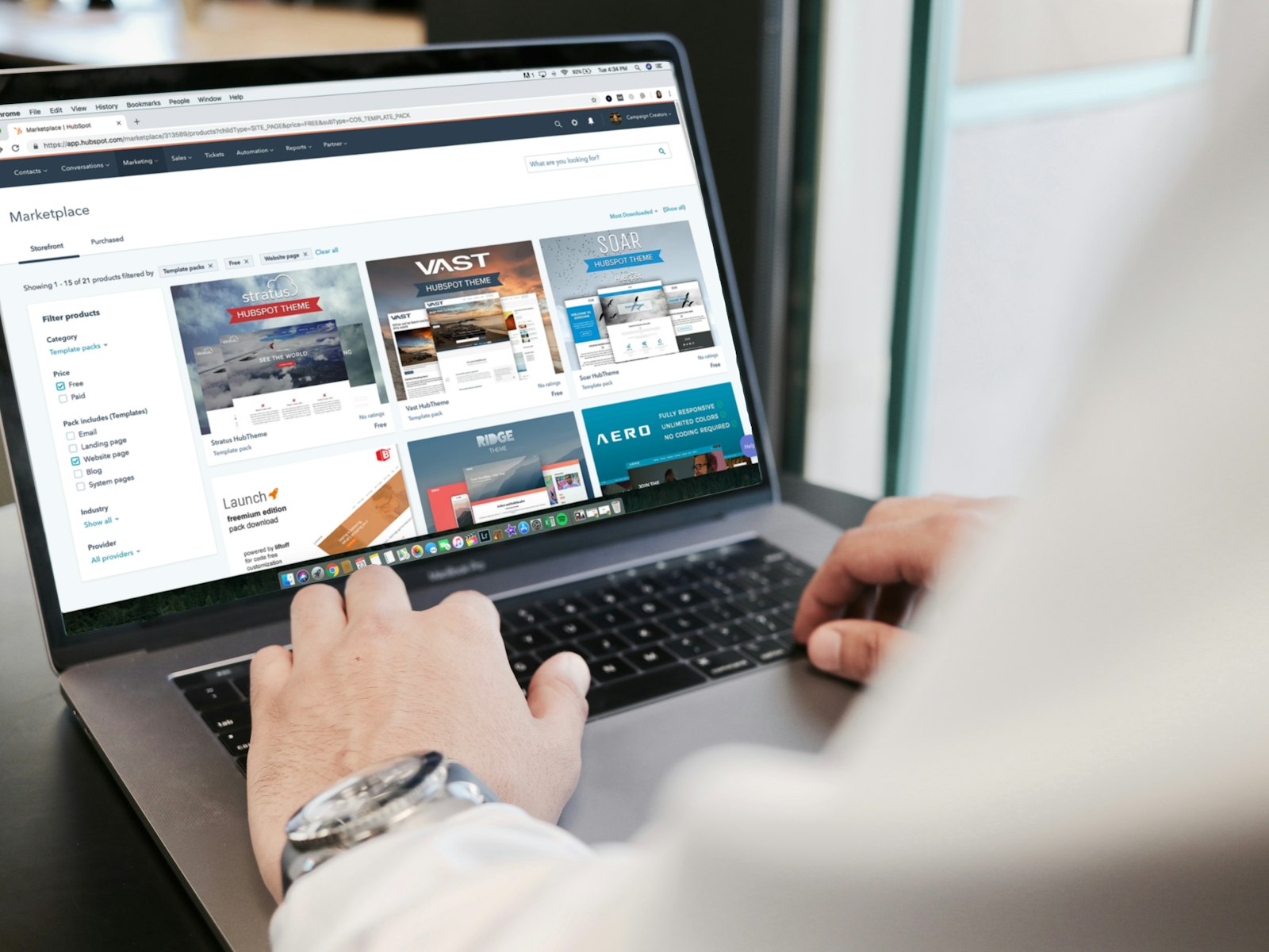 Hands typing on a laptop showing a marketing campaign console