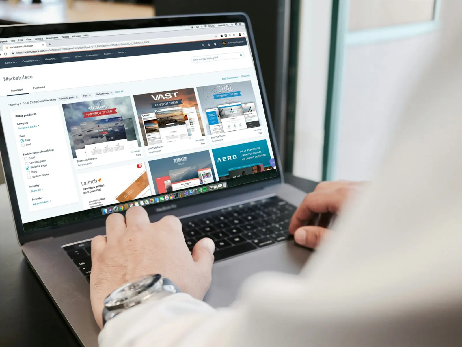 Hands typing on a laptop showing a marketing campaign console